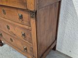 a wooden chest of drawers sitting on a concrete floor
