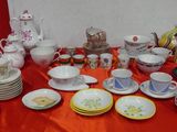 plusieurs assiettes et tasses sur une table avec une nappe rouge