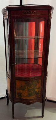 a display cabinet with a glass door in the corner