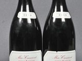 two bottles of red wine sitting next to each other on a table