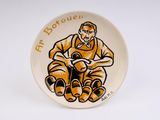a plate with a picture of a man sitting on a chair
