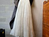 a white dress hanging on a wall next to a dresser