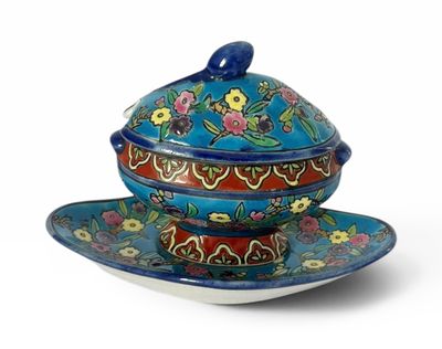 une image représentant un bol et une soucoupe bleus et rouges posés sur une assiette