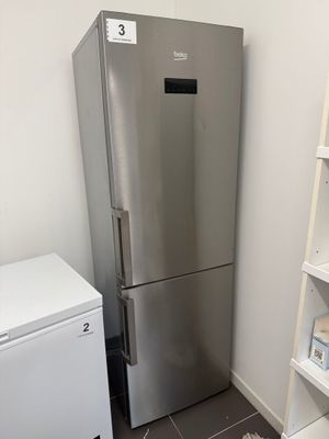 a silver refrigerator and a white refrigerator freezer in a room