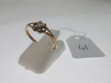 une photo d'une bague en or sertie d'un diamant et d'une étiquette