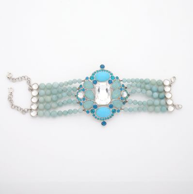 a close up of a bracelet with blue beads and a white stone
