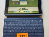 a tablet computer sitting on top of a table with a keyboard