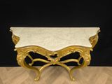 an ornately carved console table with a marble top on a wooden floor