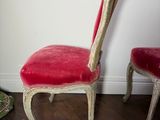 two red chairs sitting next to each other on a wooden floor