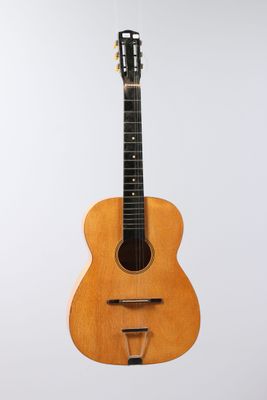 an acoustic guitar hanging from a string on a white background