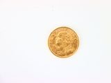 gros plan d'une pièce d'or sur une surface blanche