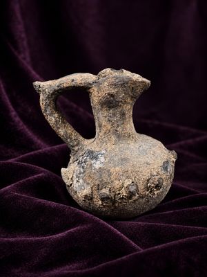 du velours violet sur lequel est posé un vase, le tout sur un tissu violet