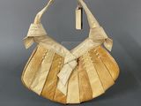 a beige purse with a bow on top of it