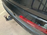 a close up of a black car with a red tail light