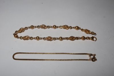 a close up of a chain and a bracelet on a table