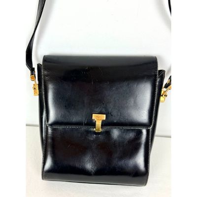 un sac à main en cuir noir muni d'une poignée en métal doré