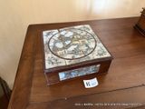 une boîte en bois ornée d'une carte, posée sur une table