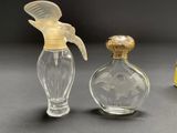 three small glass bottles with a bird on top of them