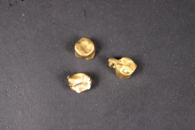 trois pièces d'or sont représentées sur un fond noir