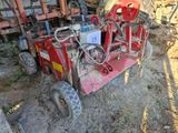 une machine rouge qui est à l'arrêt dans la poussière