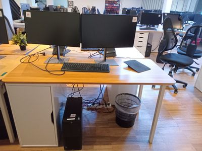 un bureau sur lequel sont posés deux écrans d'ordinateur et un clavier