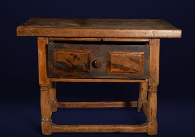 a small wooden table with two drawers on it