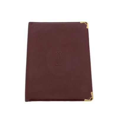 a burgundy leather notebook with a gold zipper closure