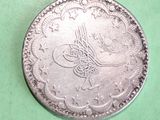 a close up of a silver coin on a green surface