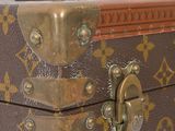 a brown and tan suitcase sitting on top of a white table