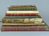 several old books stacked on top of each other on a table