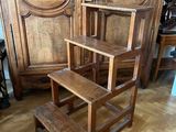 a wooden step stool sitting in front of a wooden cabinet