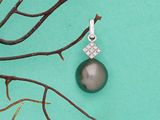 un pendentif composé d'une perle noire et de diamants, posé sur une branche