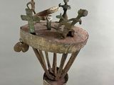 sculpture représentant un groupe de personnes assises sur une table en bois