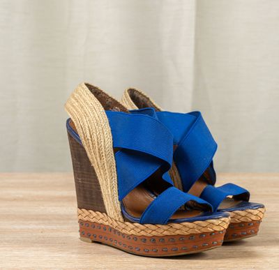 the wedged sandal is blue and has two straps on each side