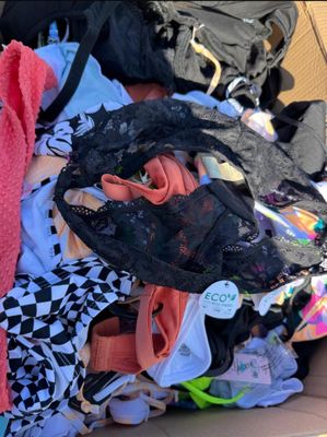 a box full of clothes and a handbag sitting on the floor