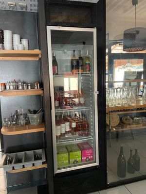 un réfrigérateur dans lequel il y a beaucoup de bouteilles et de verres