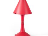 the red table lamp is on a white surface with a white background