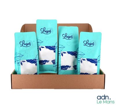 quatre paquets de café sont posés dans une boîte en carton sur un fond blanc