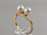 two pearl rings on top of a clear acrylic stand