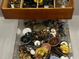 une boîte en bois remplie d'un assortiment de boutons et d'autres objets