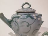 a blue and white teapot and a cup on a table