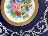 a blue plate with a gold rim with a picture of flowers on it