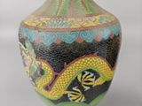 a vase with a dragon design on it on a table