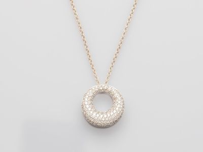 un collier en or blanc avec un pendentif circulaire monté sur une chaîne