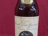une vieille bouteille d'alcool posée sur une table rouge