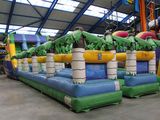 un grand toboggan aquatique gonflable orné de palmiers
