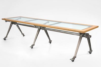 an image of a long table with a glass top and metal legs