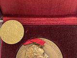 un gros plan sur une médaille d'or dans un écrin rouge