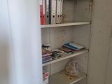 a book shelf in the corner of a small room