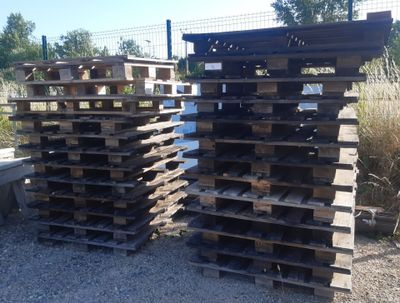 several wooden pallets stacked on top of each other on a gravel ground